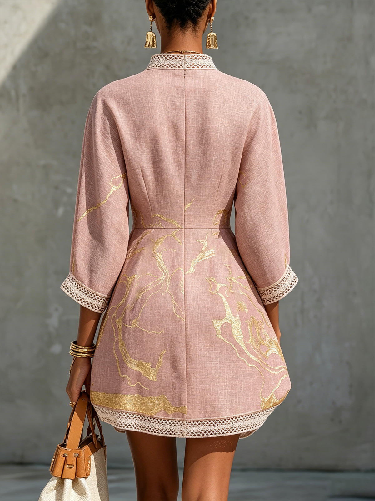 Minidress rosa con scollo a V, inserti a uncinetto e stampa dorata